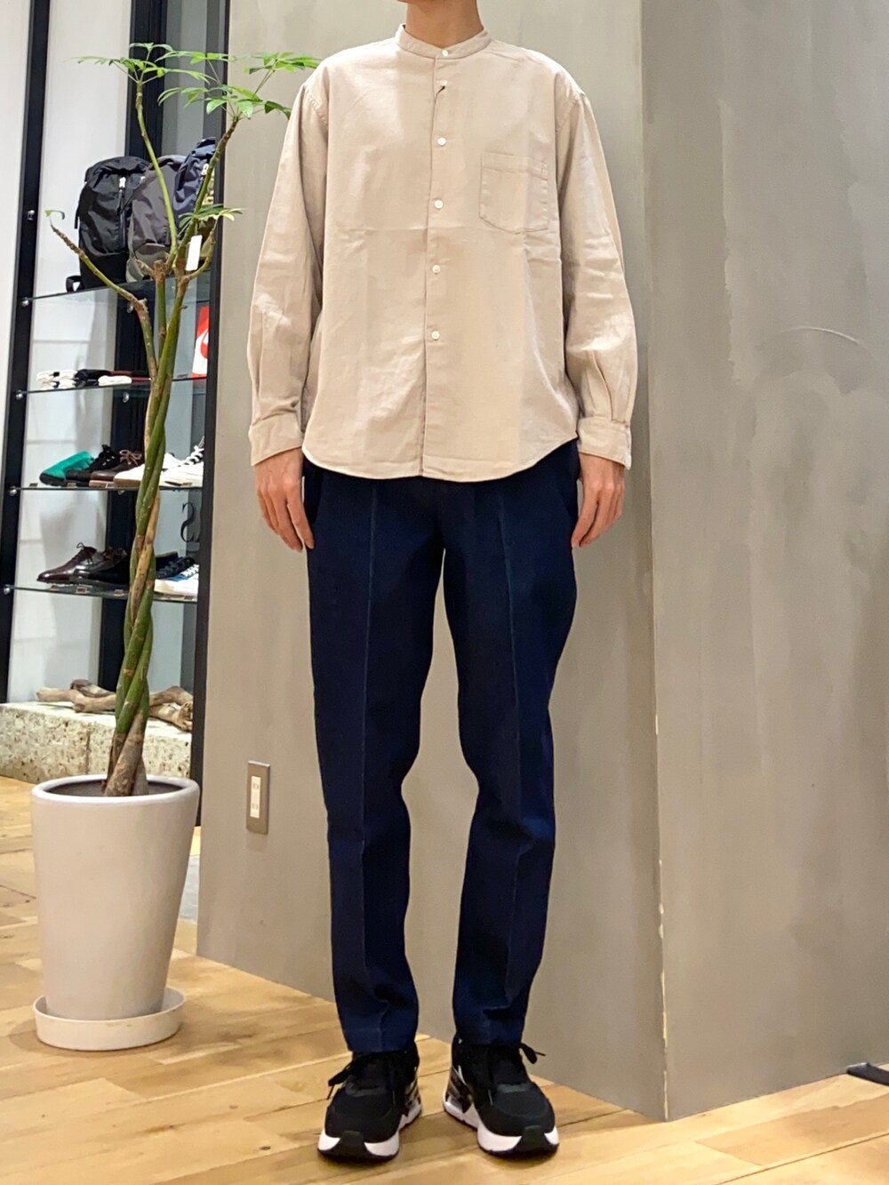 グレー系のダウンジャケット/コート、ベージュ系のシャツ/ブラウス、ブルー系のデニムパンツを着用したメンズの冬コーディネートの2枚目の写真