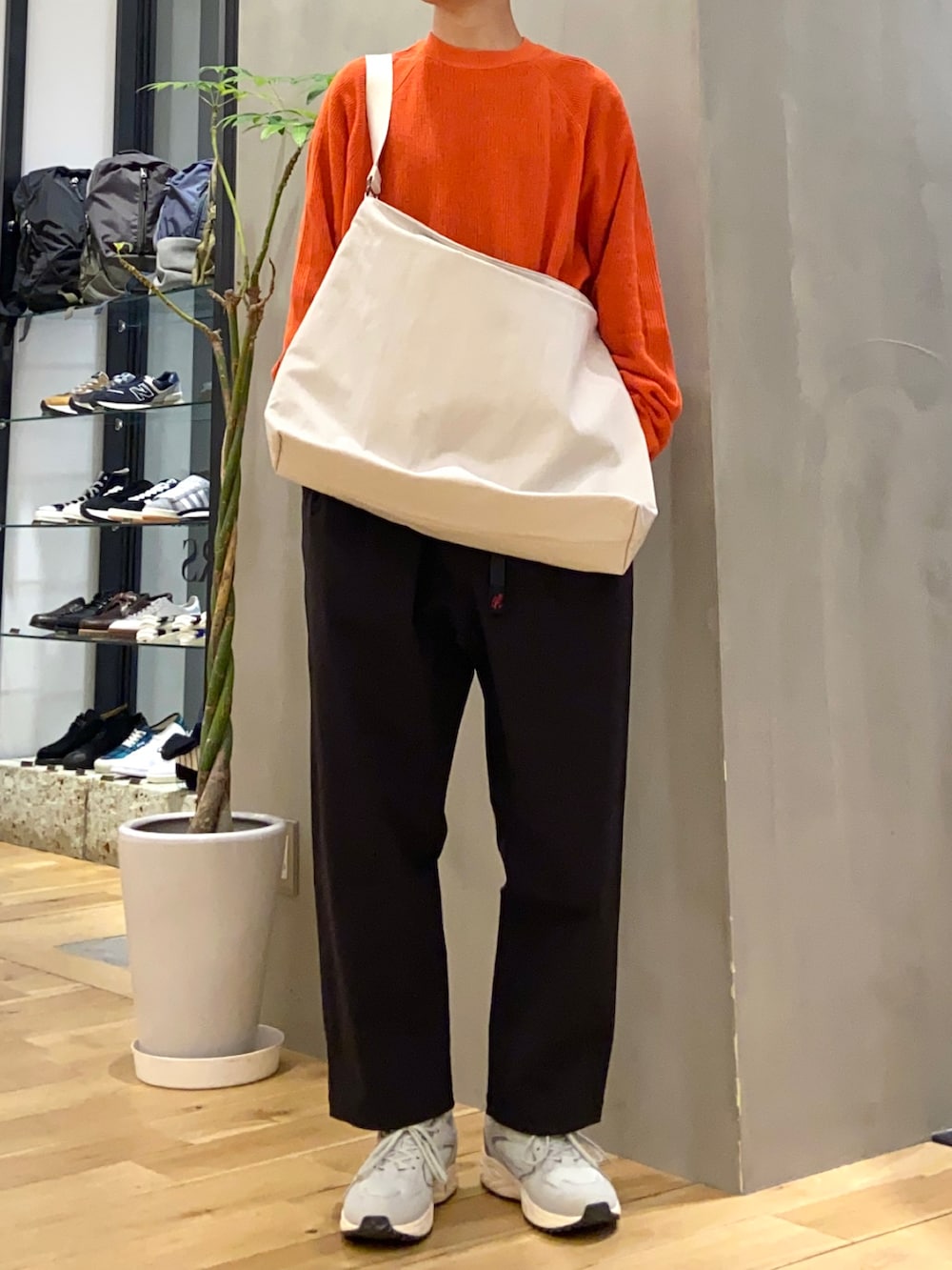 ベージュ系のその他アウター、オレンジ系のニット/セーター、グレー系のスニーカーを着用したメンズの冬コーディネートの2枚目の写真