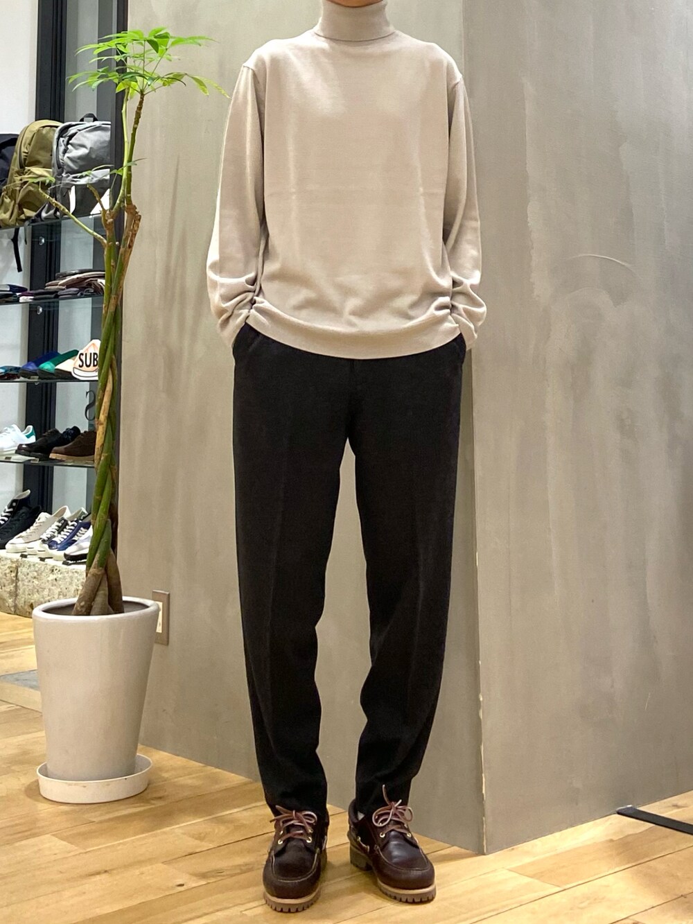 ベージュ系のダウンジャケット/コート、ベージュ系のニット/セーター、グレー系のその他パンツを着用したメンズの秋コーディネートの2枚目の写真