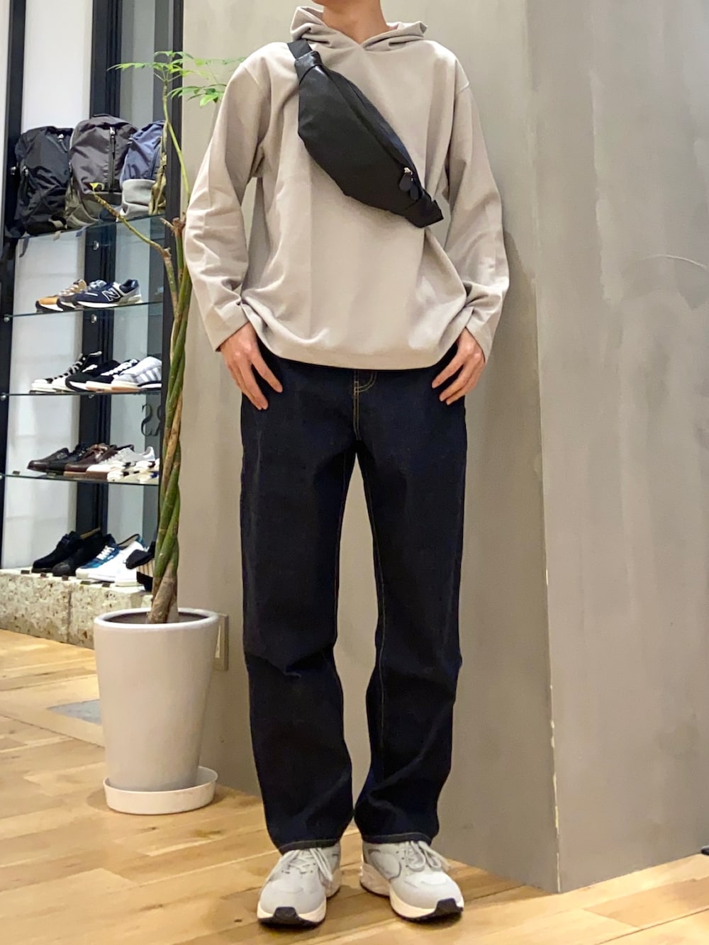 グリーン系のナイロンジャケット、ブラック系のボディバッグ/ウエストポーチ、ブルー系のデニムパンツを着用したメンズの冬コーディネートの2枚目の写真