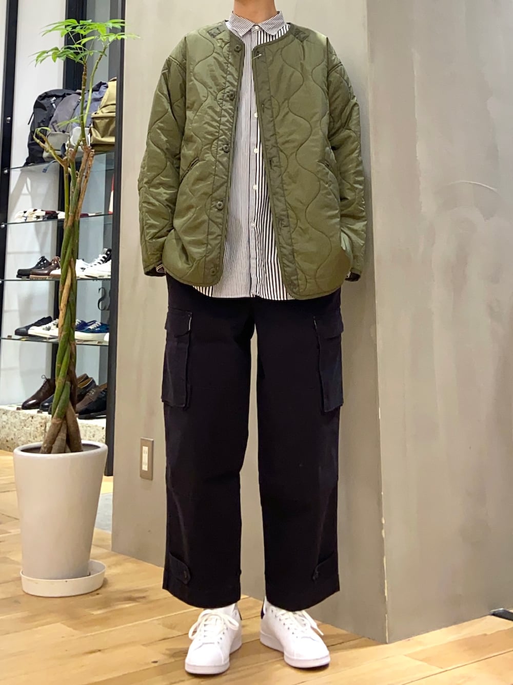 グリーン系のダウンジャケット/コート、ブルー系のシャツ/ブラウス、ブラック系のスニーカーを着用したメンズの冬コーディネートの4枚目の写真