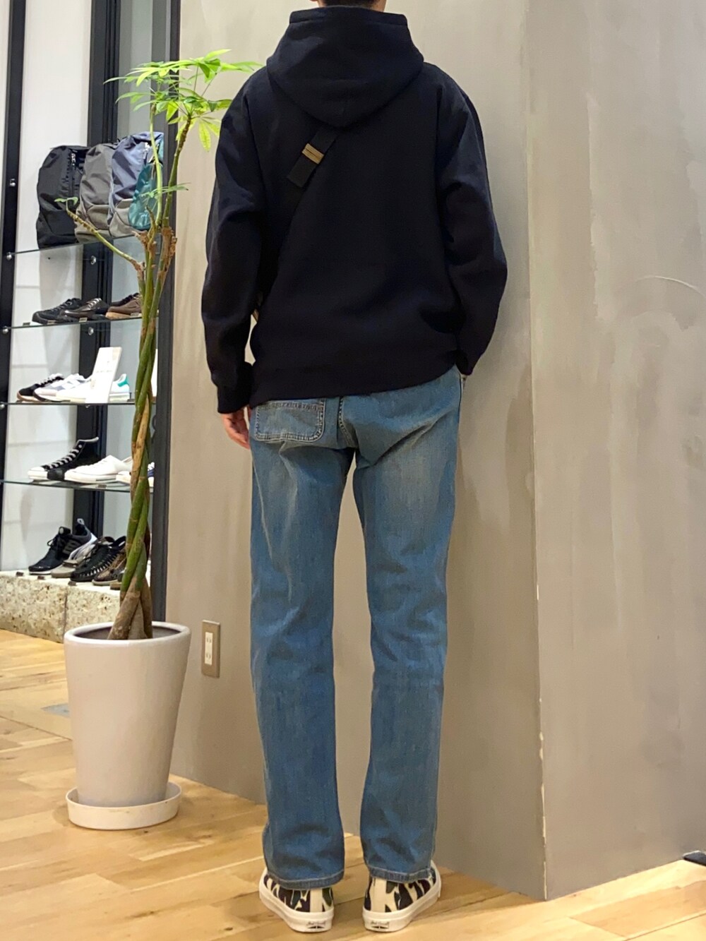 ブラック系のパーカー、ベージュ系のショルダーバッグ、ブルー系のその他パンツを着用したメンズの秋コーディネートの3枚目の写真