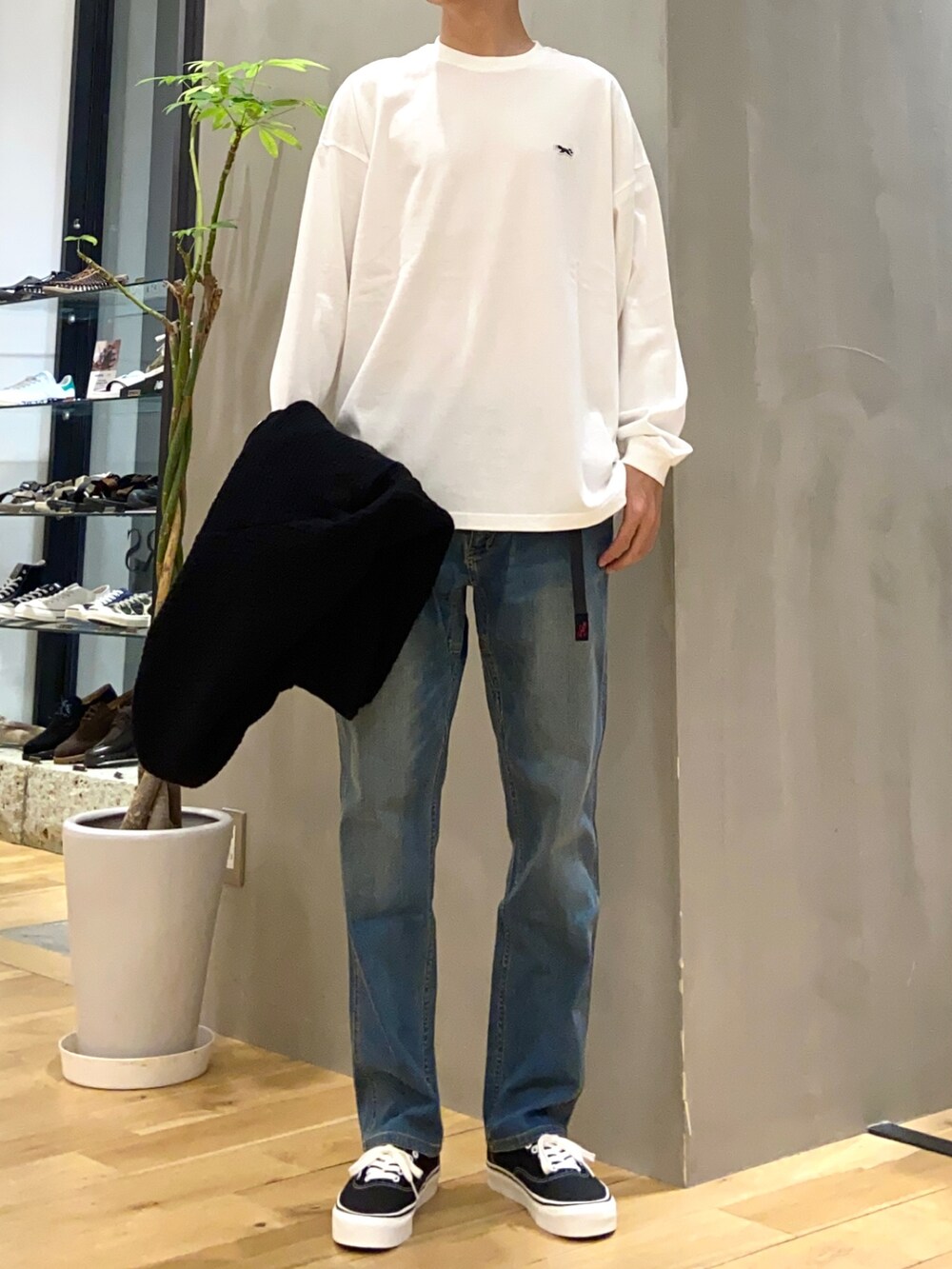 ブラック系のブルゾン、ホワイト系のTシャツ/カットソー、ブラック系のスニーカーを着用したメンズの夏コーディネートの2枚目の写真