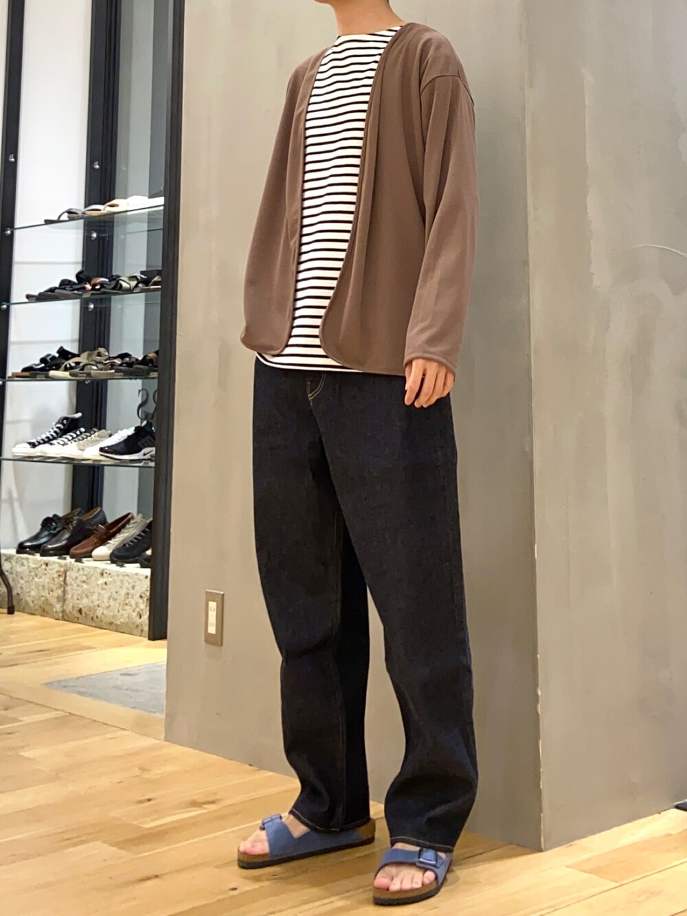 ブラウン系のカーディガン/ボレロ、ブルー系のデニムパンツ、ブルー系のサンダルを着用したメンズの春コーディネートの3枚目の写真