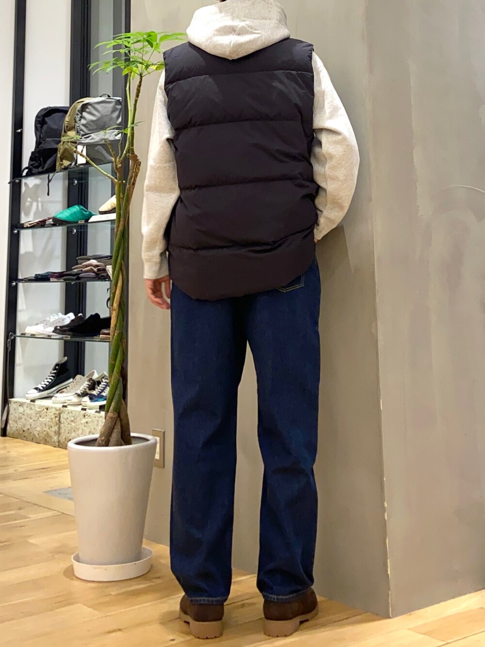 ブラック系のダウンベスト、グレー系のパーカー、ブルー系のデニムパンツを着用したメンズの冬コーディネートの3枚目の写真