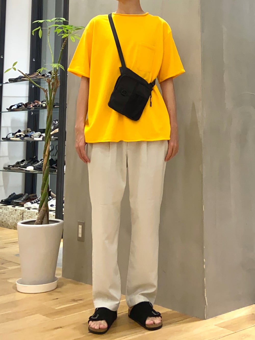 イエロー系のTシャツ/カットソー、ブラック系のショルダーバッグ、ホワイト系のその他パンツを着用したメンズの夏コーディネートの4枚目の写真