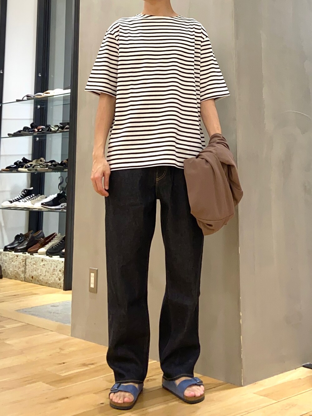 ブラウン系のカーディガン/ボレロ、ブルー系のデニムパンツ、ブルー系のサンダルを着用したメンズの春コーディネートの2枚目の写真