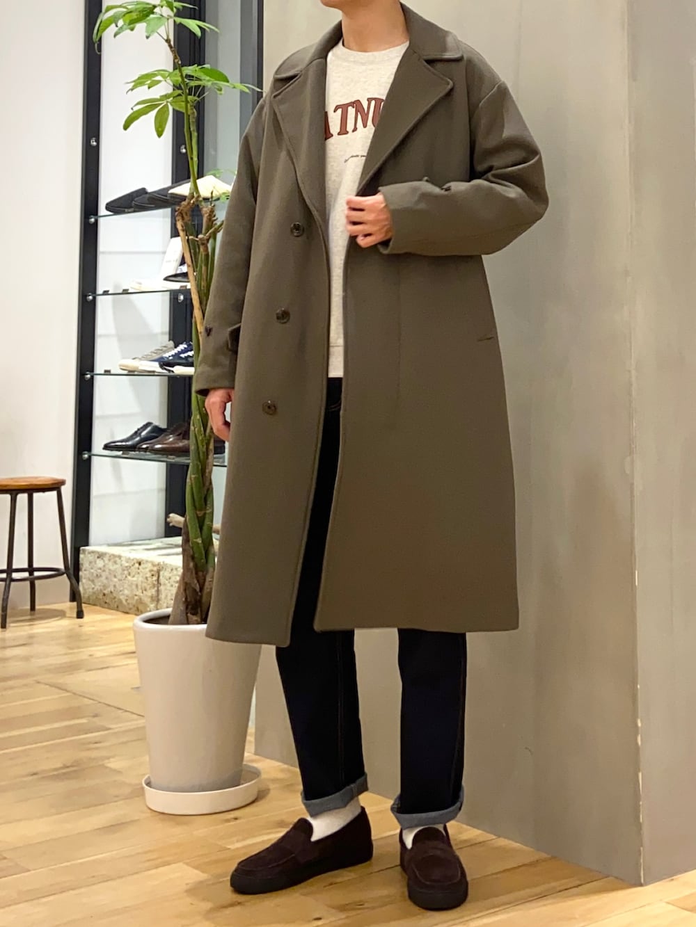 ベージュ系のチェスターコート、ホワイト系のスウェット、ブラウン系のローファーを着用したメンズの冬コーディネートの4枚目の写真