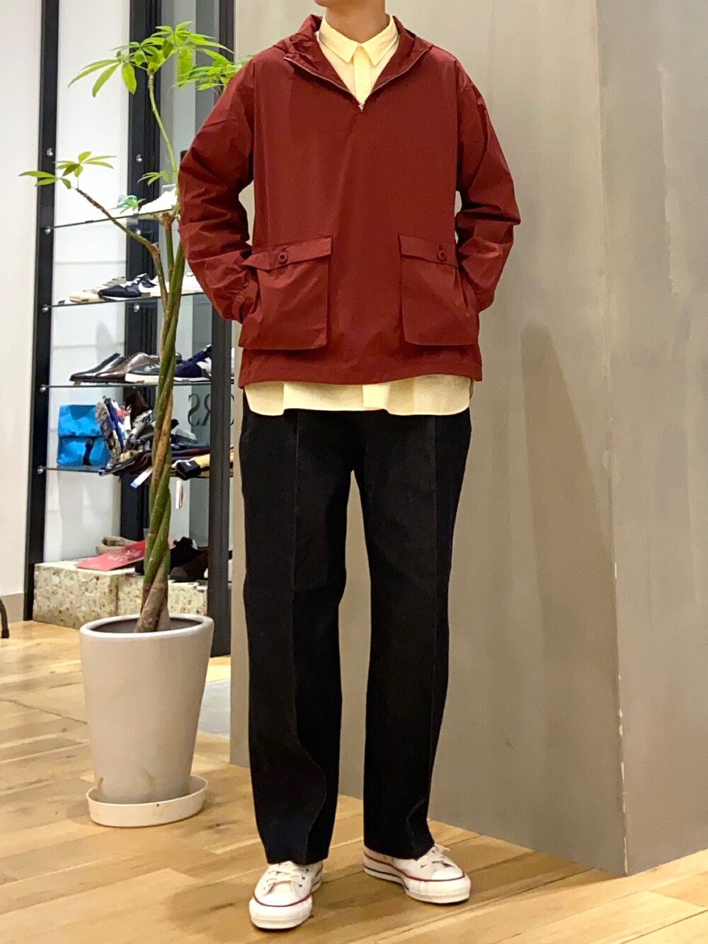 レッド系のマウンテンパーカー、イエロー系のシャツ/ブラウス、ブルー系のデニムパンツを着用したメンズの冬コーディネートの3枚目の写真