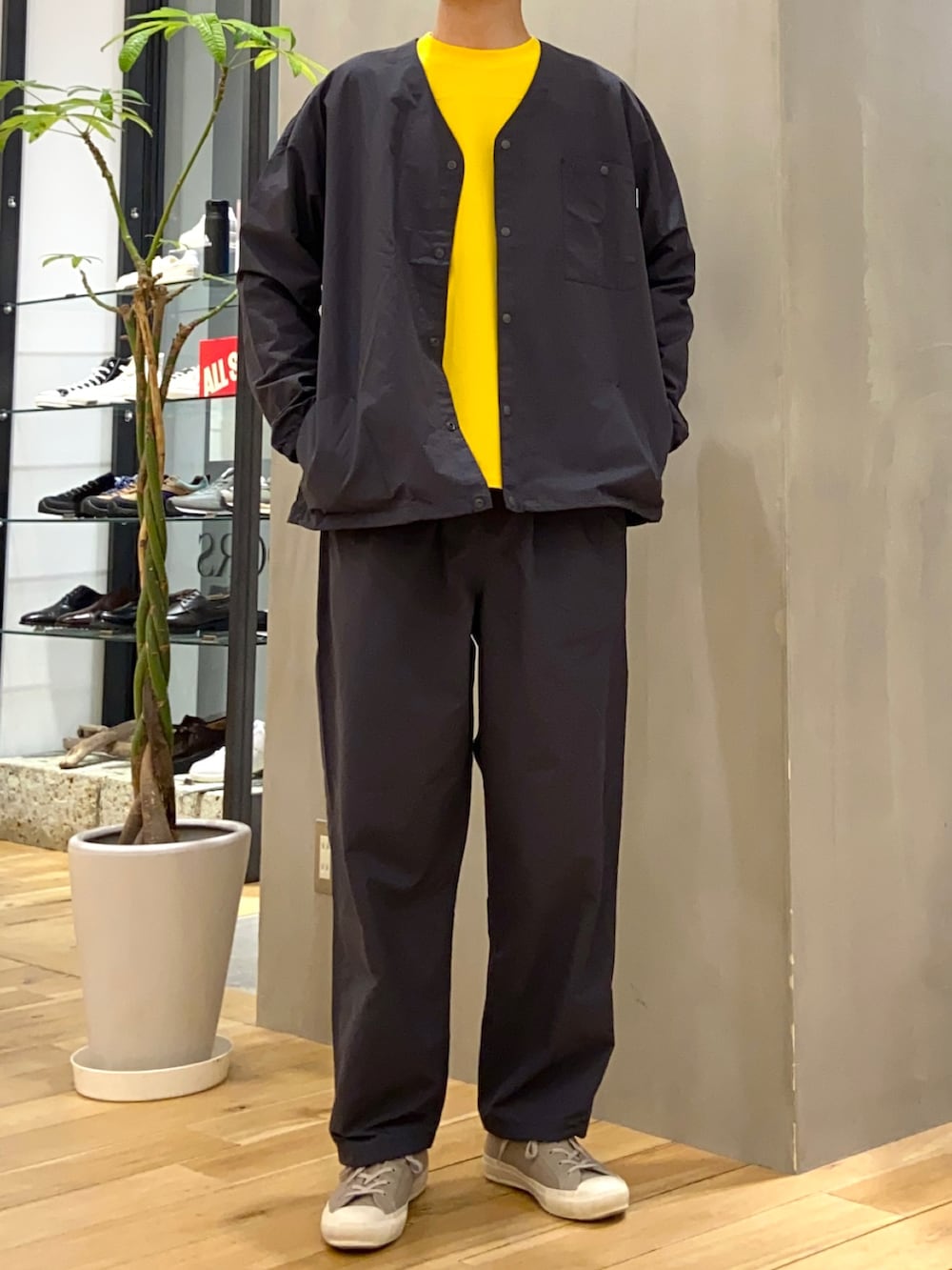 グレー系のナイロンジャケット、グレー系のその他パンツ、イエロー系のTシャツ/カットソーを着用したメンズの春コーディネートの4枚目の写真