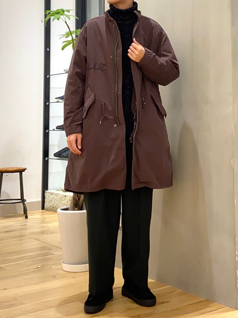 ブラウン系のモッズコート、ブラック系のニット/セーター、ブラック系のブーツを着用したメンズの冬コーディネートの3枚目の写真