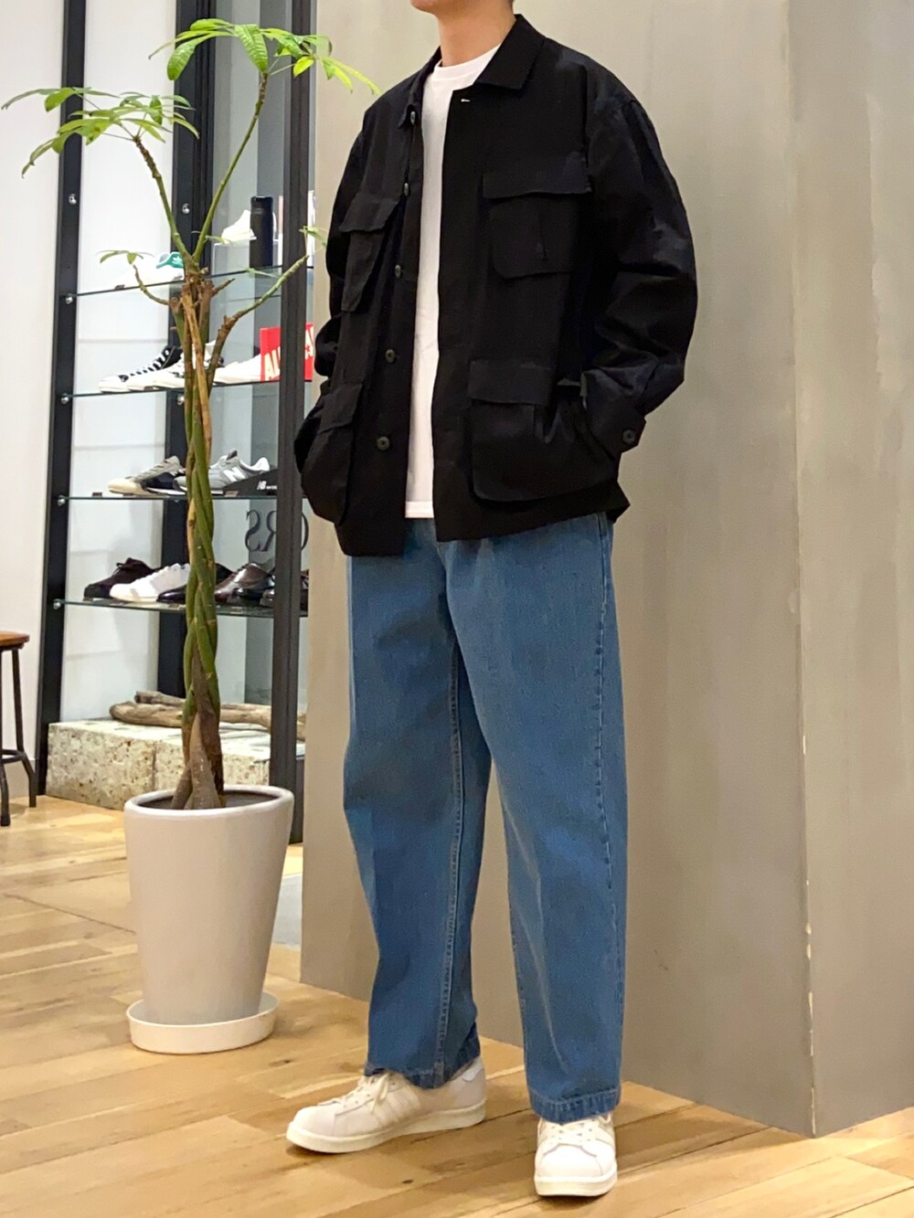 ブラック系のミリタリージャケット、ブルー系のデニムパンツ、ベージュ系のスニーカーを着用したメンズの春コーディネートの5枚目の写真