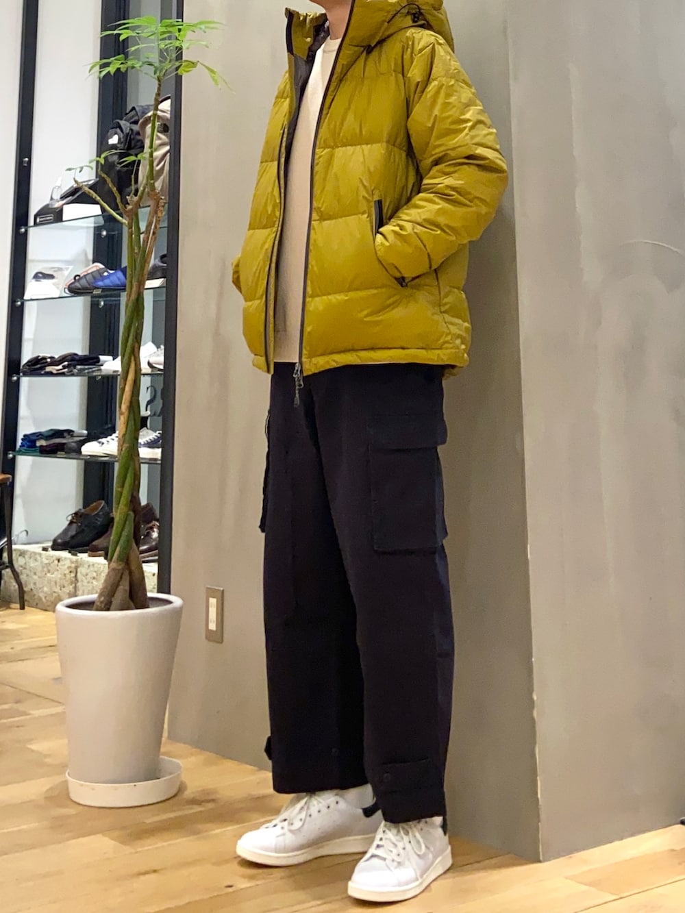 イエロー系のダウンジャケット/コート、ホワイト系のニット/セーター、ブルー系のカーゴパンツを着用したメンズの冬コーディネートの3枚目の写真