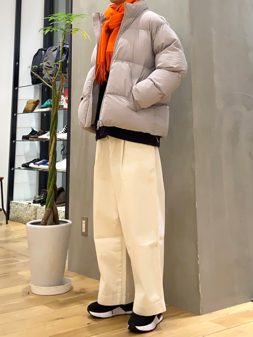 グレー系のダウンジャケット/コート、ホワイト系のデニムパンツ、ブルー系のニット/セーターを着用したメンズの冬コーディネートの3枚目の写真