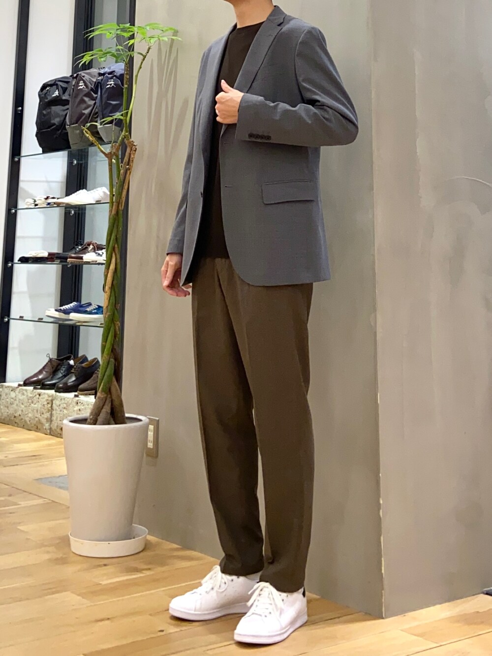 グレー系のその他アウター、ブラウン系のニット/セーター、ブラック系のスニーカーを着用したメンズの冬コーディネートの2枚目の写真