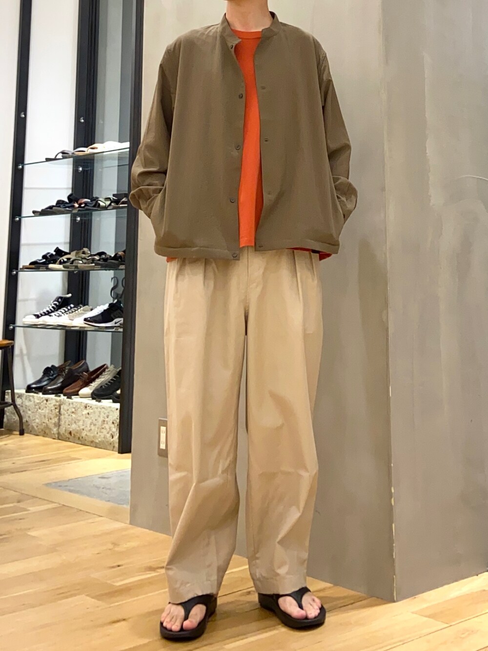 グリーン系のブルゾン、レッド系のTシャツ/カットソー、ベージュ系のその他パンツを着用したメンズの夏コーディネートの4枚目の写真