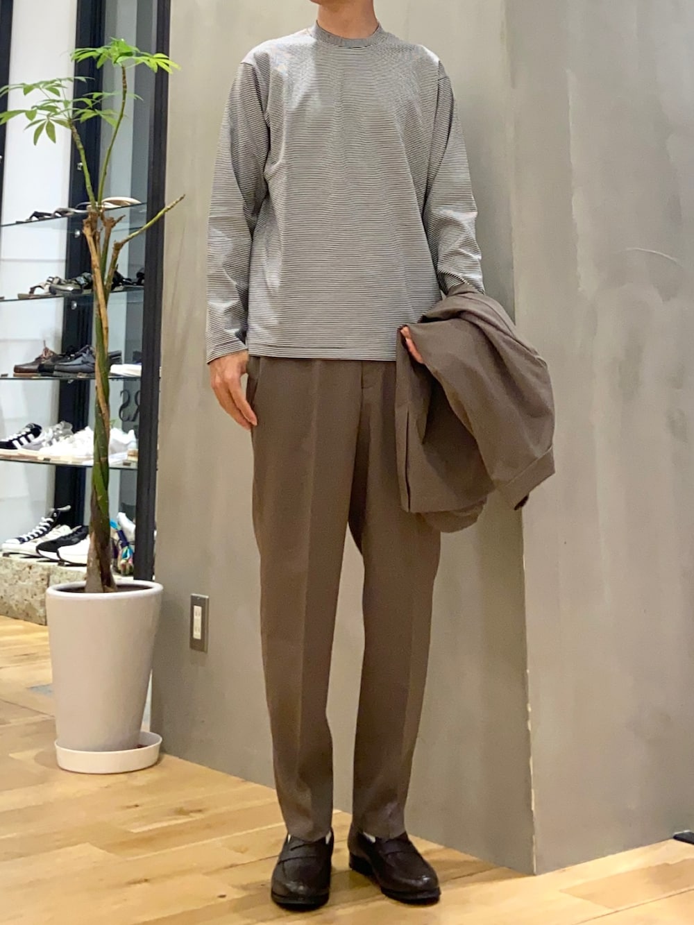 ブラウン系のスーツジャケット、ホワイト系のシャツ/ブラウス、ブラウン系のスーツパンツを着用したメンズの夏コーディネートの2枚目の写真