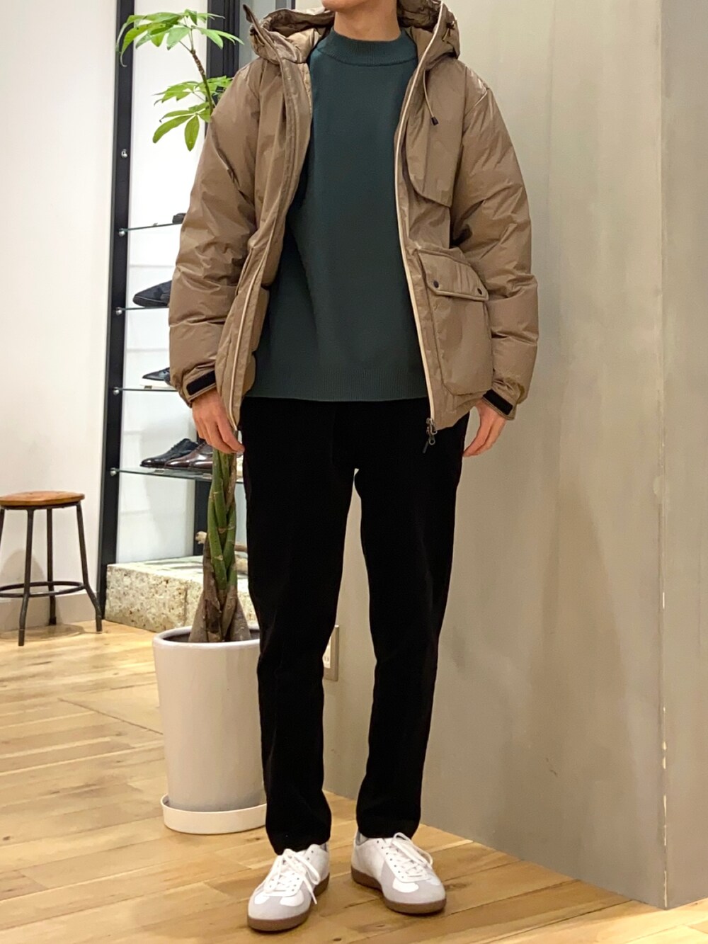 ベージュ系のダウンジャケット/コート、グリーン系のニット/セーター、ホワイト系のスニーカーを着用したメンズの冬コーディネートの3枚目の写真