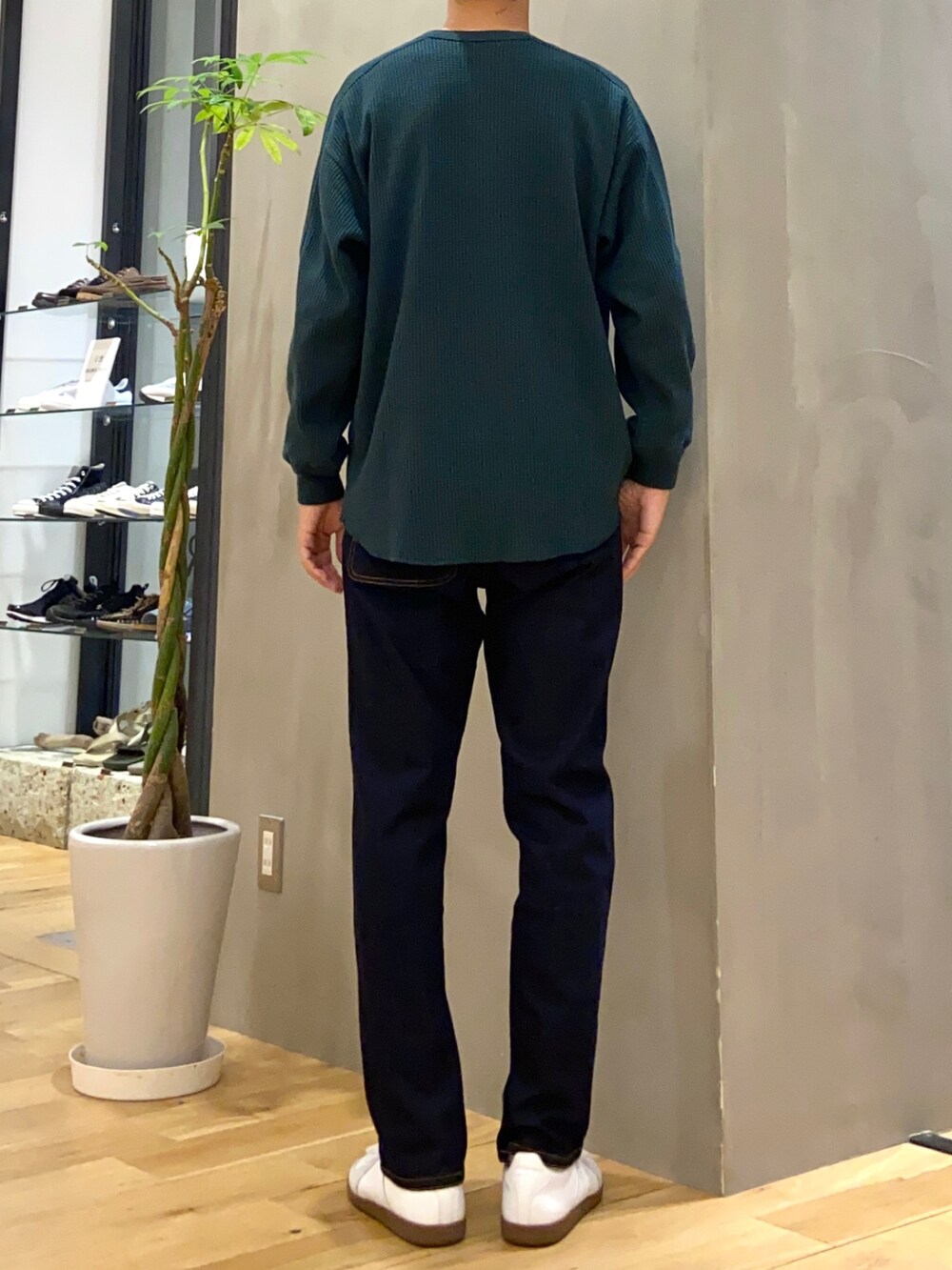 グリーン系のTシャツ/カットソー、ブルー系のその他パンツ、ホワイト系のスニーカーを着用したメンズの秋コーディネートの3枚目の写真