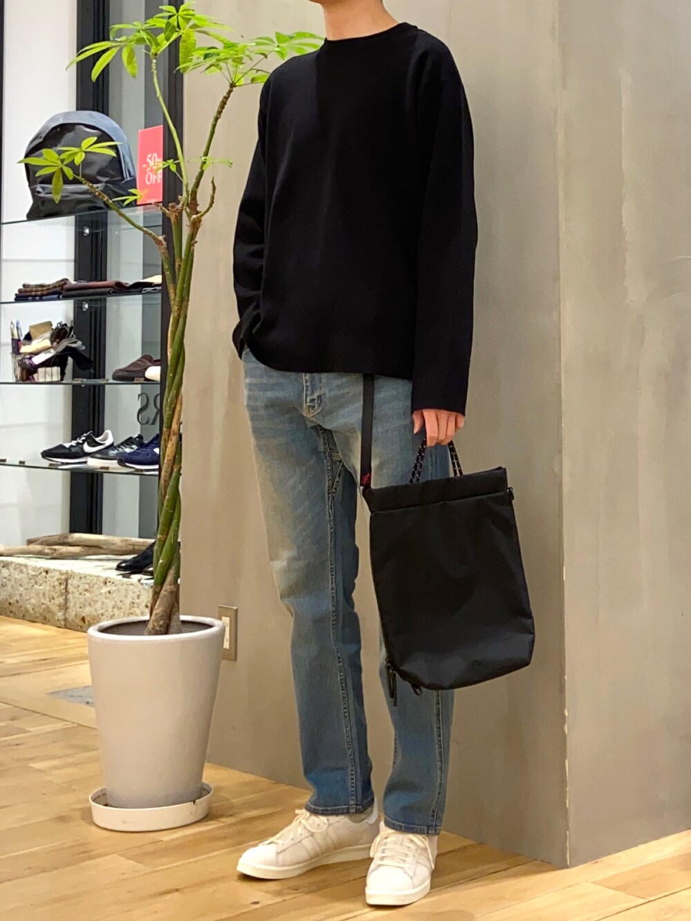 ブラック系のニット/セーター、ブルー系のその他パンツ、ベージュ系のスニーカーを着用したメンズの冬コーディネートの2枚目の写真