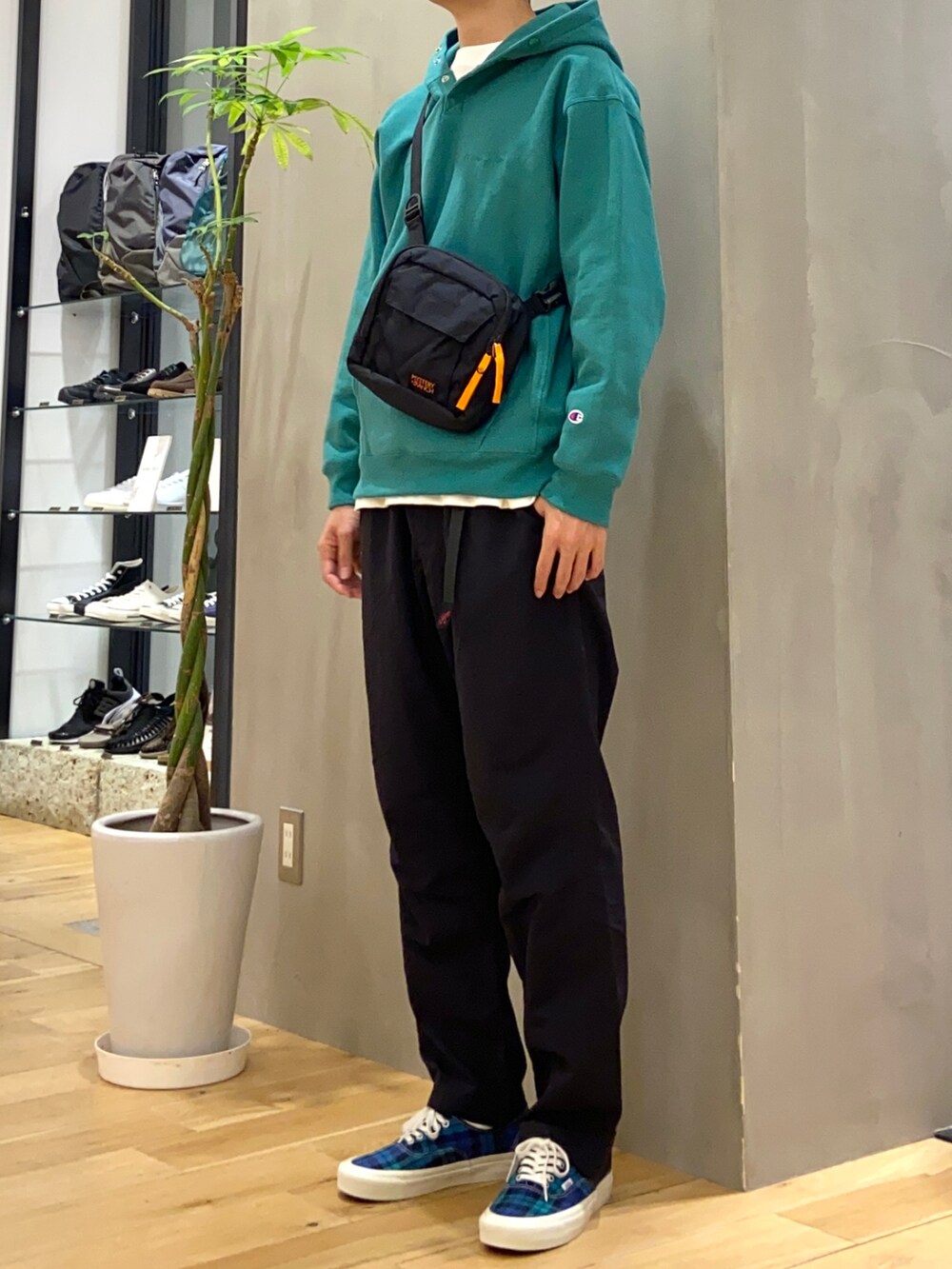 ブラック系のショルダーバッグ、グリーン系のパーカー、ホワイト系のTシャツ/カットソーを着用したメンズの冬コーディネートの2枚目の写真