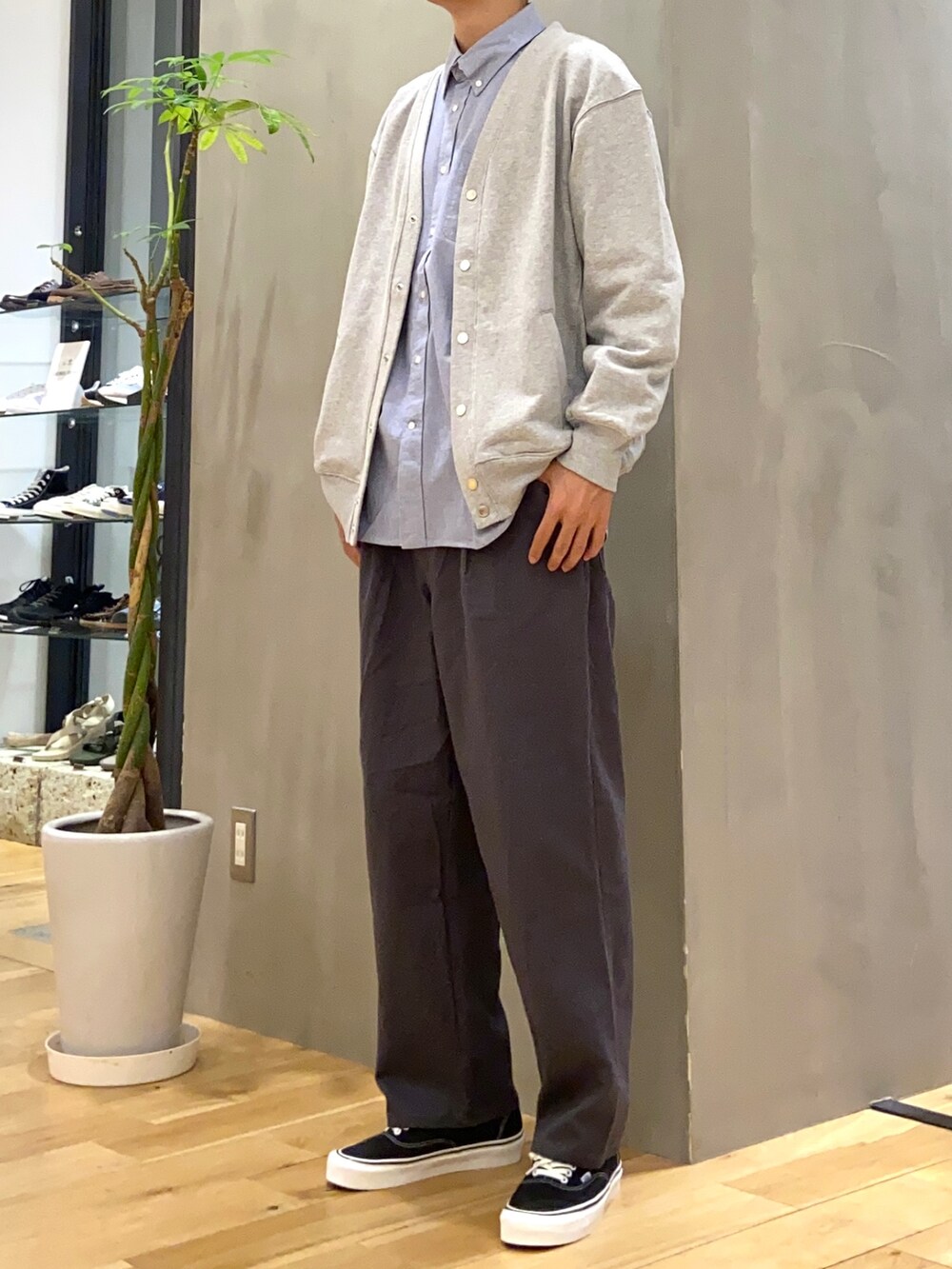 グレー系のカーディガン/ボレロ、ブルー系のシャツ/ブラウス、ブラック系のスニーカーを着用したメンズの秋コーディネートの2枚目の写真