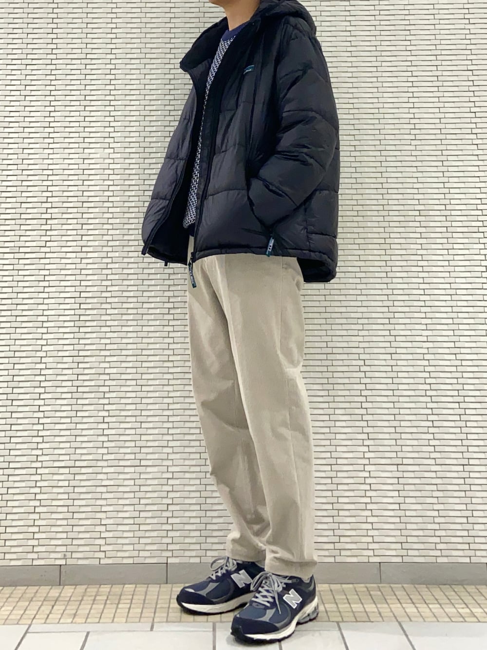 ブルー系のニット/セーター、ベージュ系のその他パンツ、ブルー系のスニーカーを着用したメンズの秋コーディネートの2枚目の写真