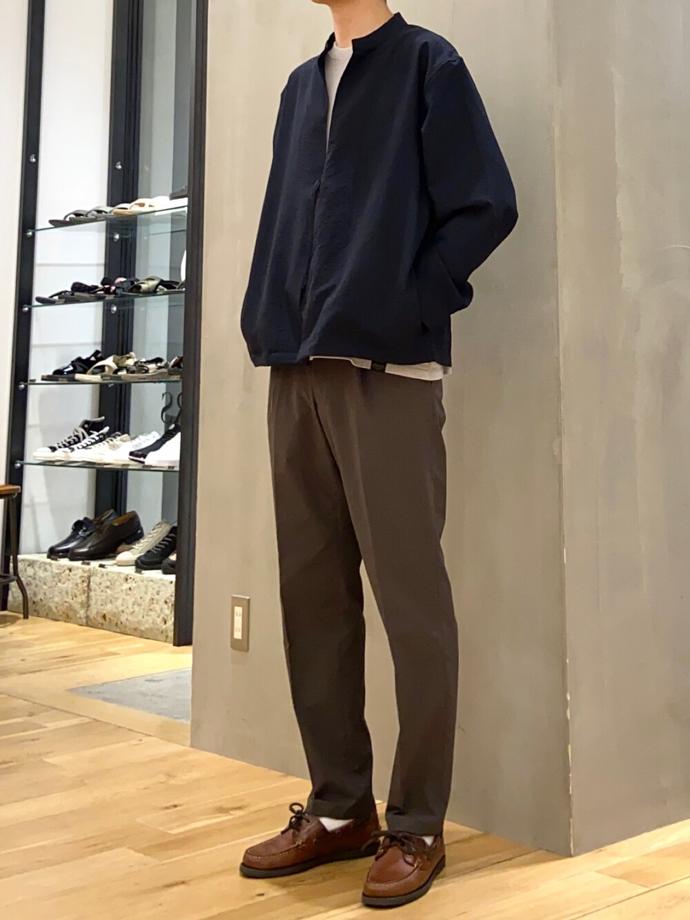 グレー系のTシャツ/カットソー、ブルー系のブルゾン、グリーン系のスーツパンツを着用したメンズの春コーディネートの3枚目の写真