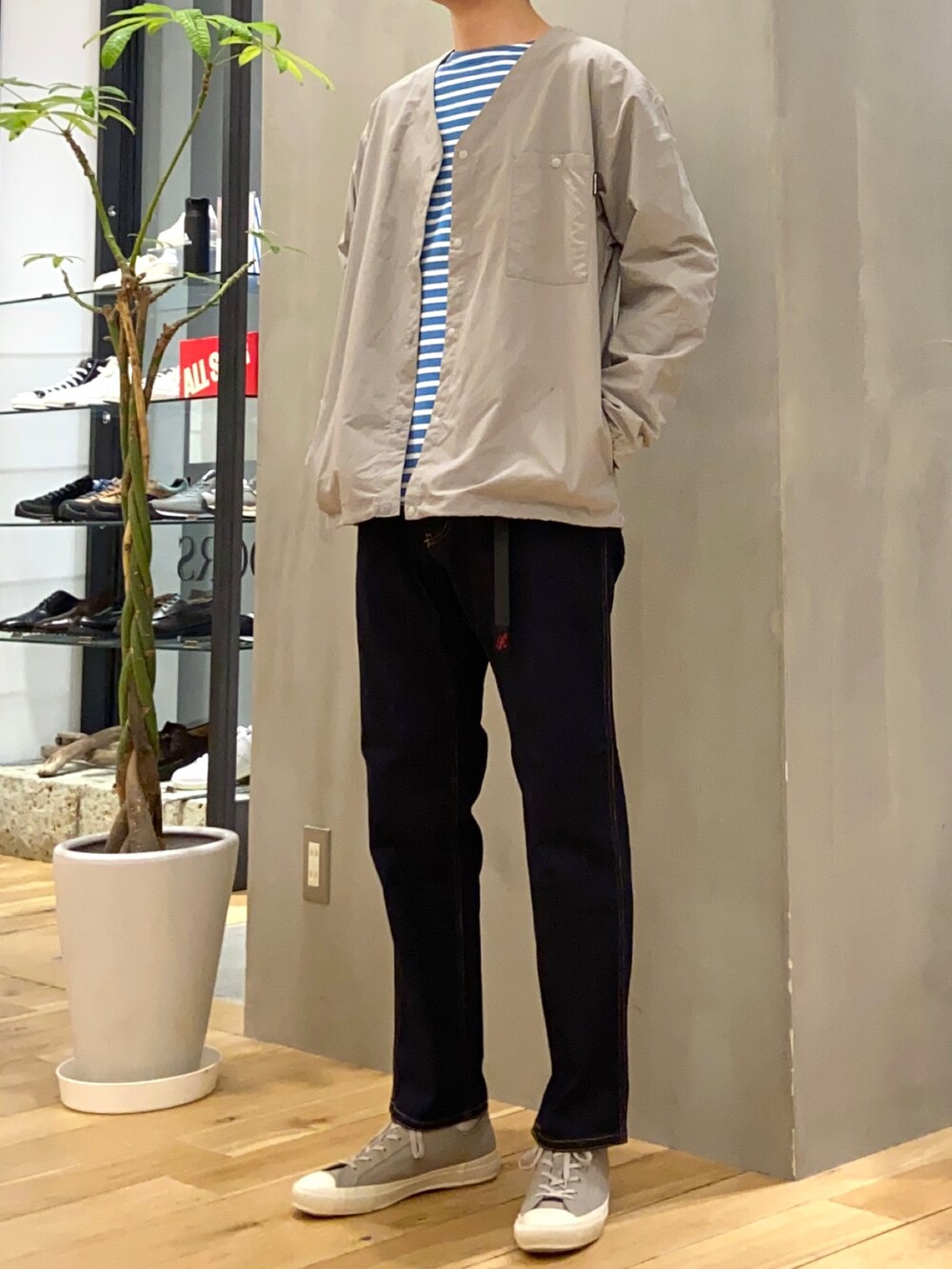 グレー系のナイロンジャケット、ホワイト系のTシャツ/カットソー、グレー系のスニーカーを着用したメンズの春コーディネートの2枚目の写真