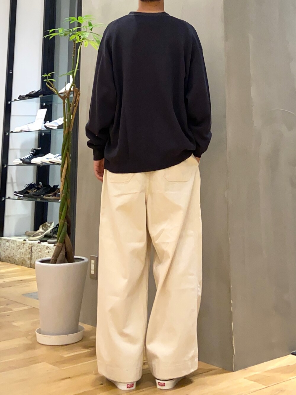 グレー系のカーディガン/ボレロ、ホワイト系のTシャツ/カットソー、ブラック系のスニーカーを着用したメンズの秋コーディネートの3枚目の写真