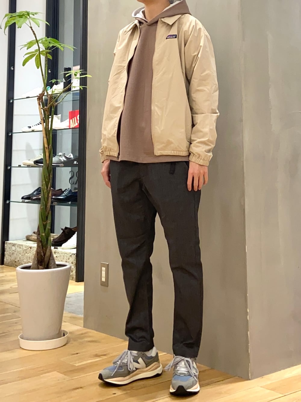 ブラウン系のパーカー、グレー系のその他パンツ、グレー系のスニーカーを着用したメンズの春コーディネートの4枚目の写真