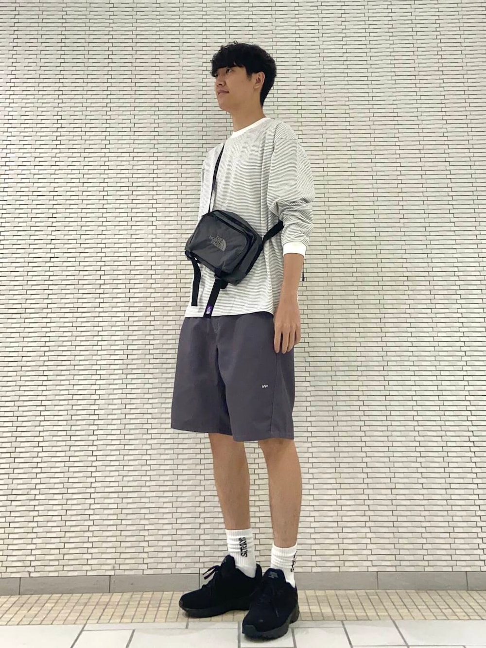 グレー系のその他パンツ、ブラック系のスニーカー、ホワイト系のTシャツ/カットソーを着用したメンズの夏コーディネートの2枚目の写真