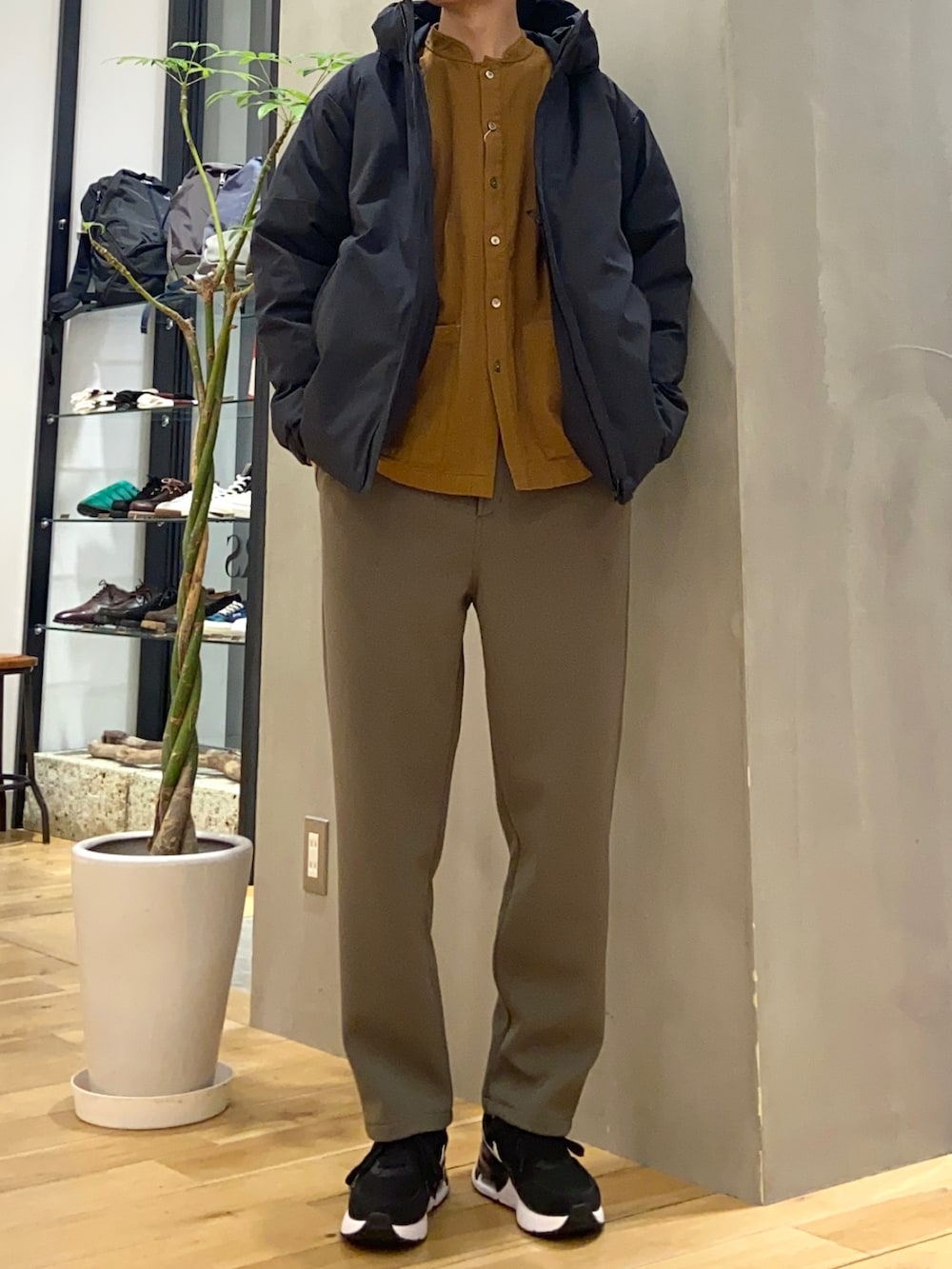 ブラック系のダウンジャケット/コート、ブラウン系のシャツ/ブラウス、グリーン系のその他パンツを着用したメンズの冬コーディネートの2枚目の写真