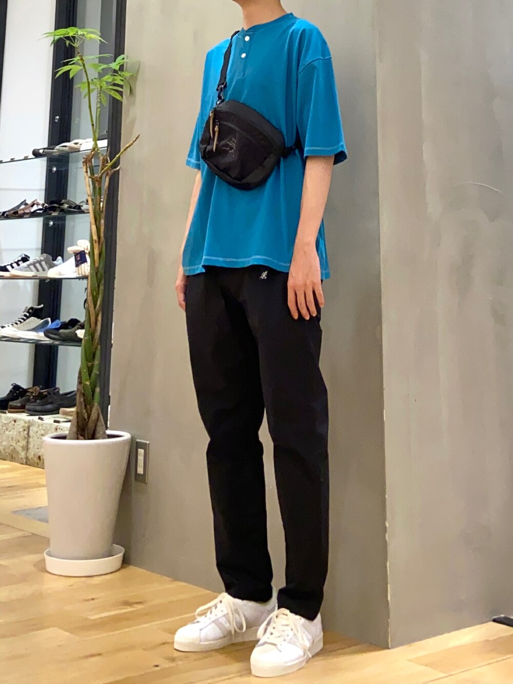 ブルー系のTシャツ/カットソー、ブラック系のショルダーバッグ、ブラック系のその他パンツを着用したメンズの春コーディネートの2枚目の写真