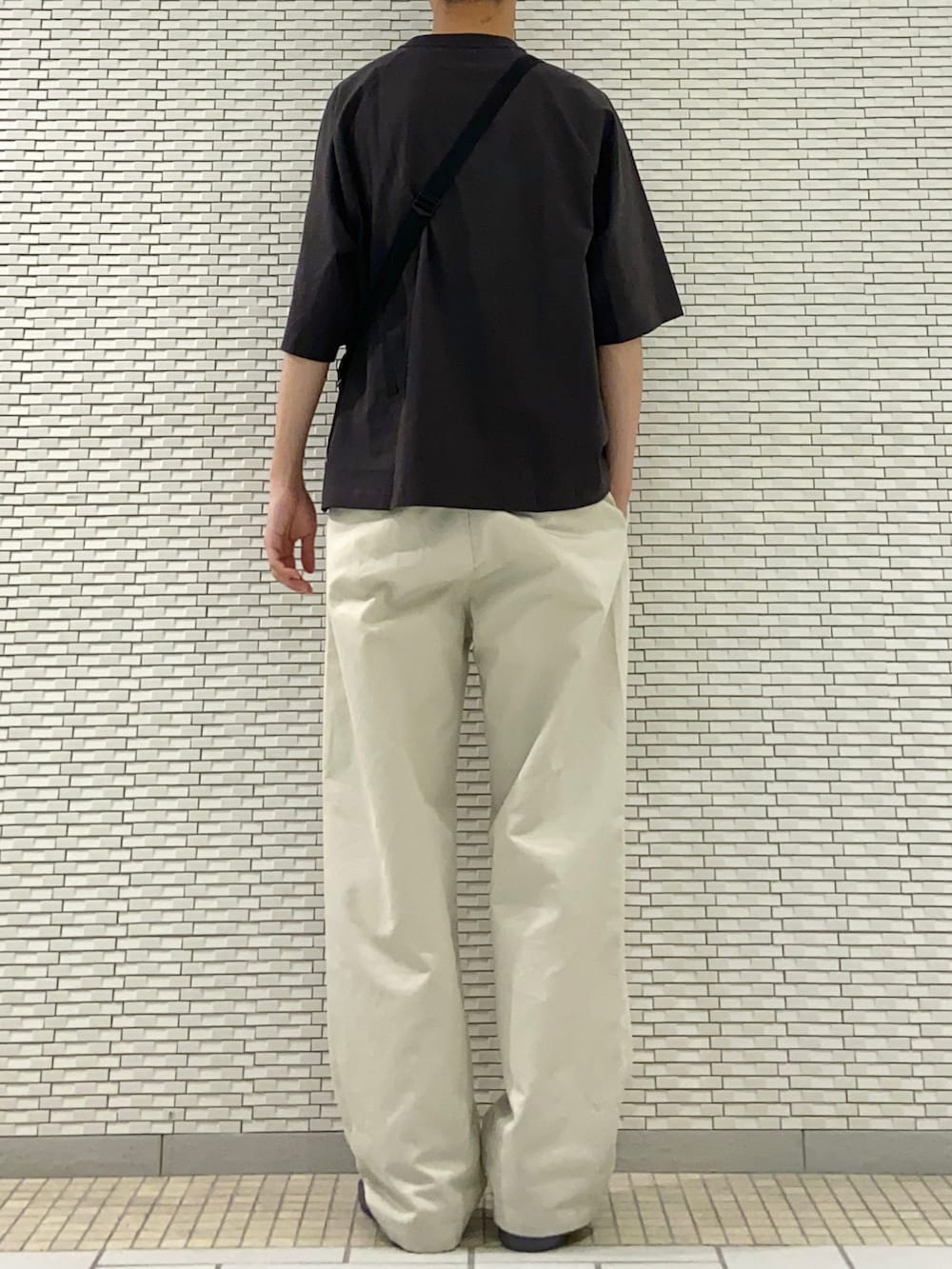 ブラック系のTシャツ/カットソー、ホワイト系のその他パンツ、グレー系のサンダルを着用したメンズの春コーディネートの3枚目の写真