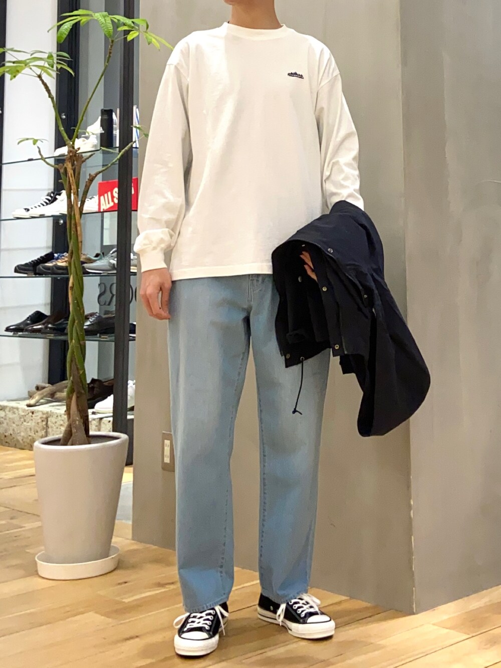 ブラック系のマウンテンパーカー、ホワイト系のTシャツ/カットソー、ブルー系のデニムパンツを着用したメンズの春コーディネートの2枚目の写真
