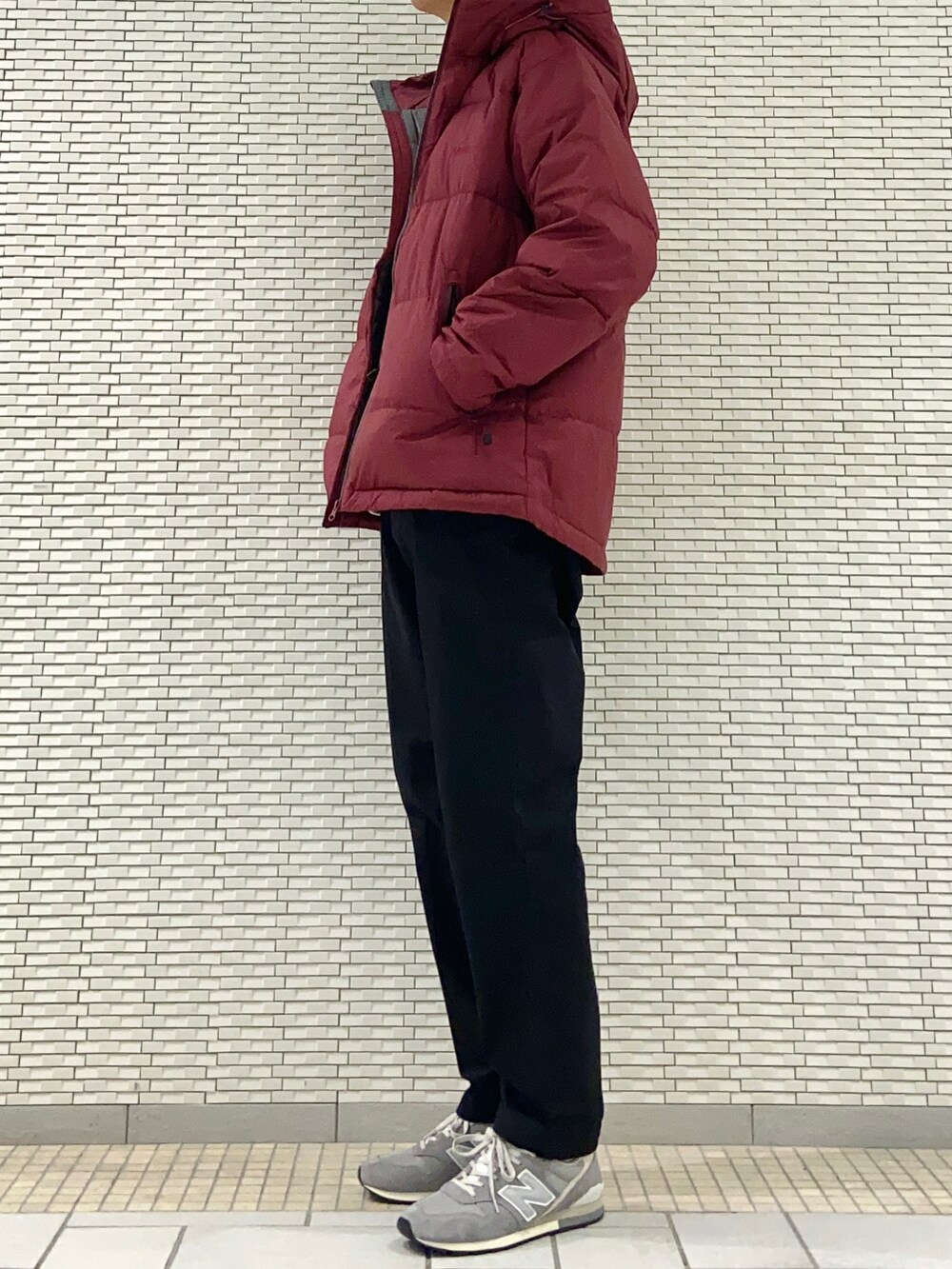 レッド系のダウンジャケット/コート、ブラック系のチノパンツ、グレー系のスニーカーを着用したメンズの秋コーディネートの2枚目の写真
