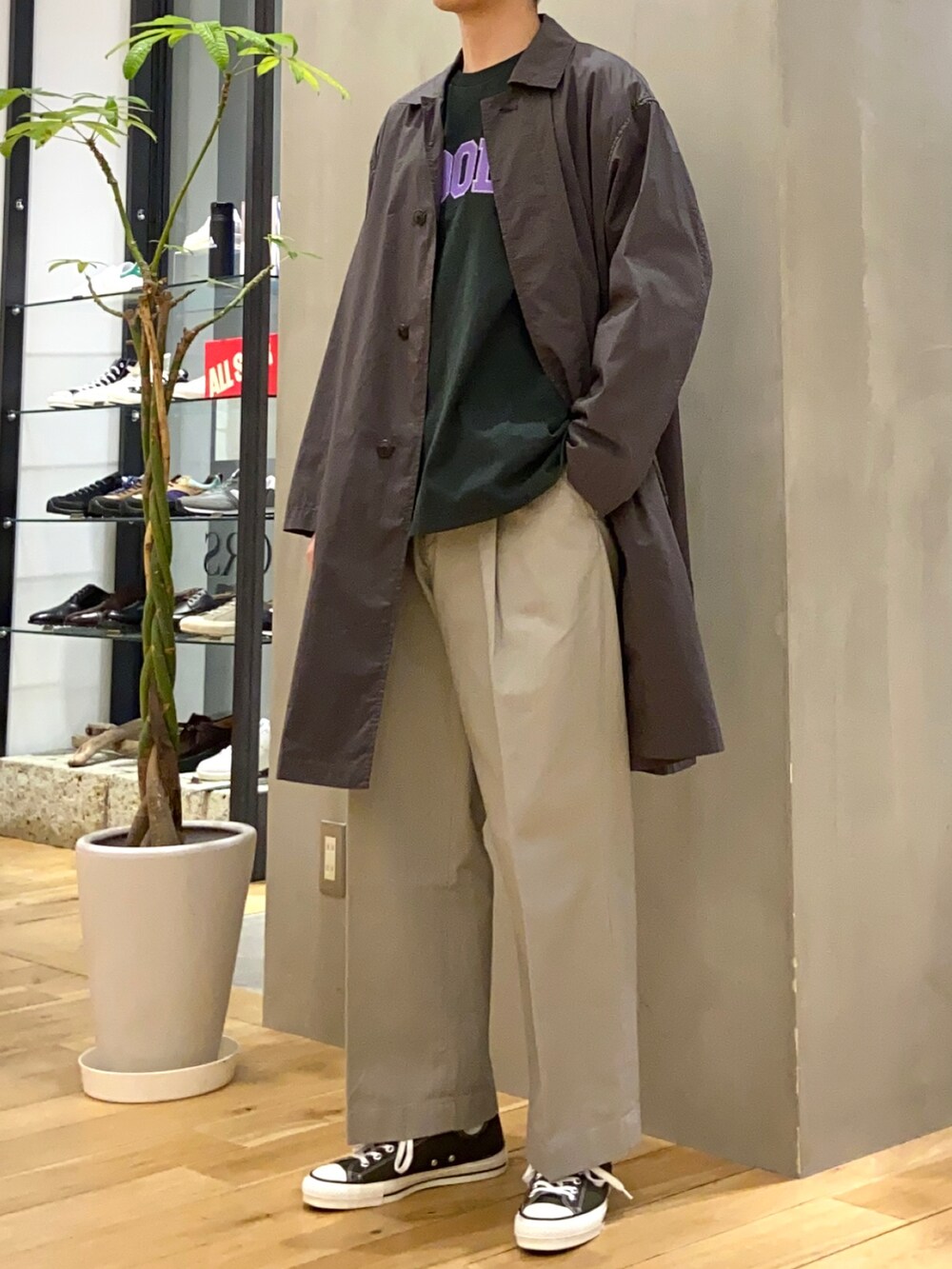 グレー系のステンカラーコート、グリーン系のTシャツ/カットソー、グレー系のその他パンツを着用したメンズの春コーディネートの4枚目の写真