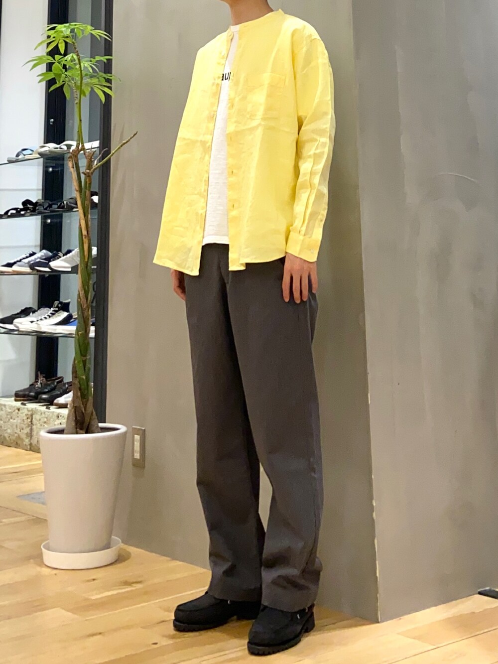 イエロー系のシャツ/ブラウス、ホワイト系のTシャツ/カットソー、グレー系のチノパンツを着用したメンズの春コーディネートの3枚目の写真
