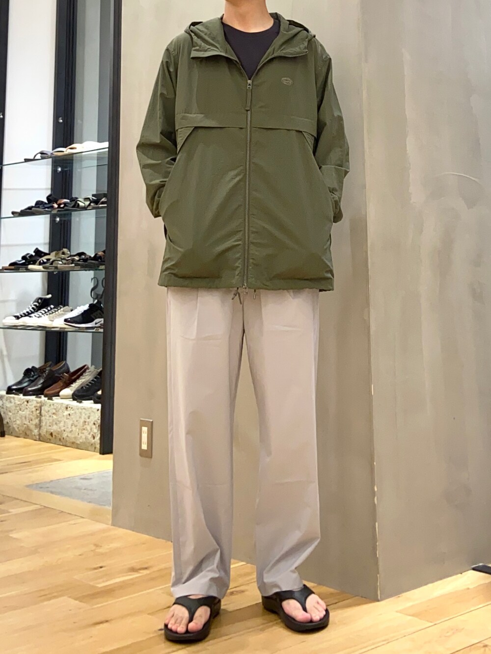 グリーン系のマウンテンパーカー、グレー系のその他パンツ、ブラック系のサンダルを着用したメンズの夏コーディネートの4枚目の写真