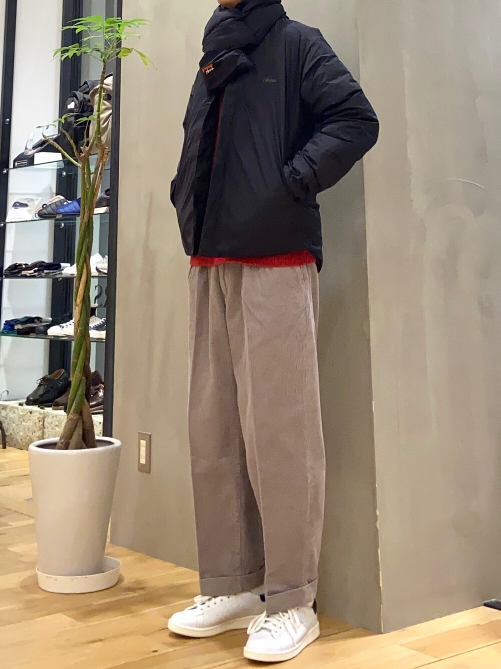 レッド系のニット/セーター、グレー系のその他パンツ、グリーン系のスニーカーを着用したメンズの冬コーディネートの3枚目の写真