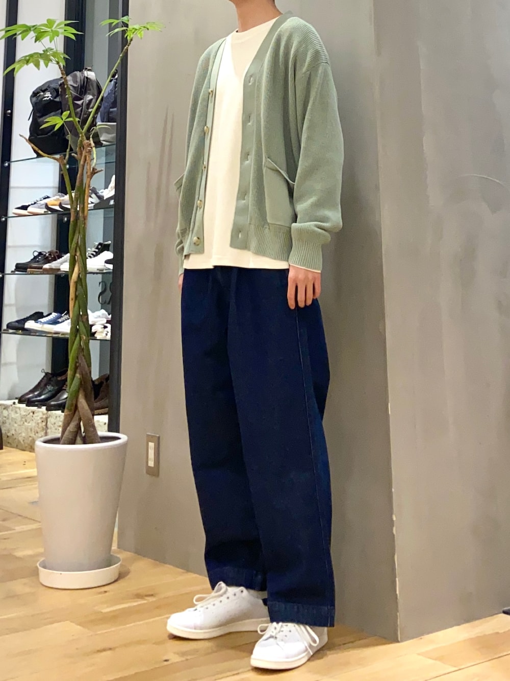 グリーン系のカーディガン/ボレロ、ホワイト系のTシャツ/カットソー、ブルー系のデニムパンツを着用したメンズの冬コーディネートの2枚目の写真