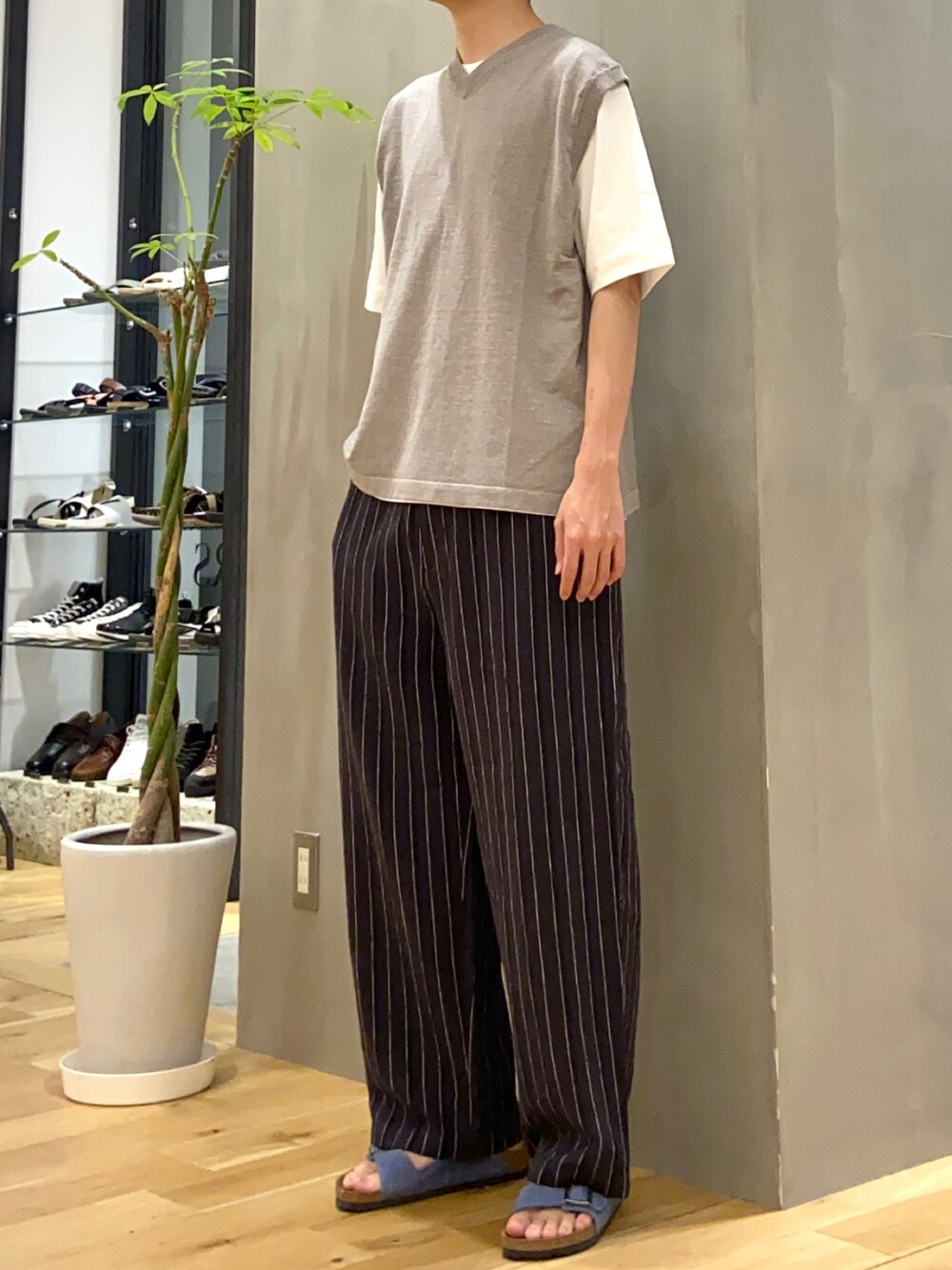 グレー系のベスト、ホワイト系のTシャツ/カットソー、ブルー系のサンダルを着用したメンズの夏コーディネートの2枚目の写真