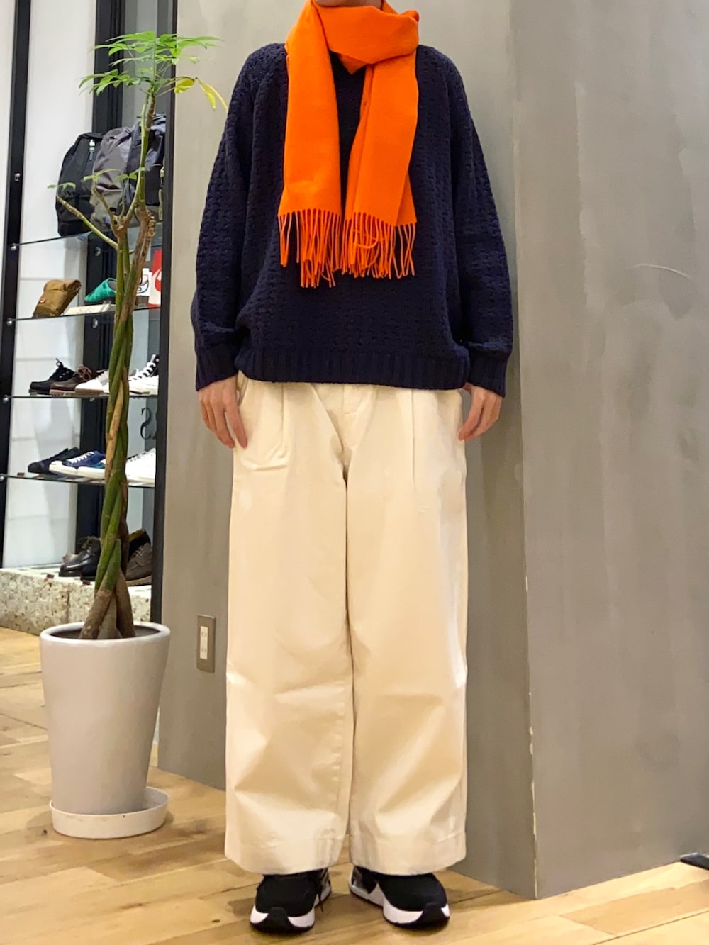 グレー系のダウンジャケット/コート、ホワイト系のデニムパンツ、ブルー系のニット/セーターを着用したメンズの冬コーディネートの4枚目の写真