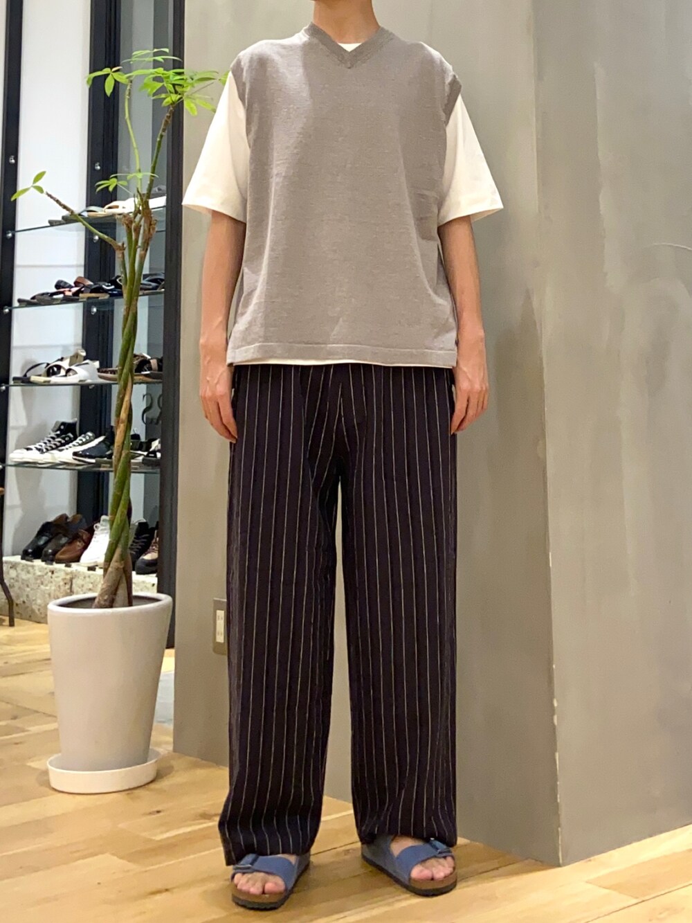 グレー系のベスト、ホワイト系のTシャツ/カットソー、ブルー系のサンダルを着用したメンズの夏コーディネートの3枚目の写真