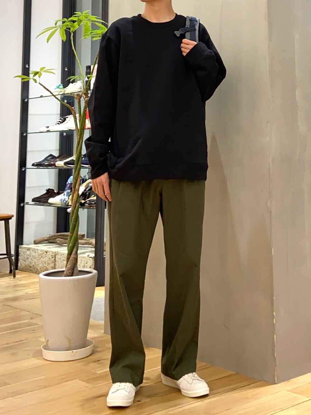 グリーン系のチノパンツ、ブルー系のバックパック/リュック、ベージュ系のスニーカーを着用したメンズの冬コーディネートの3枚目の写真