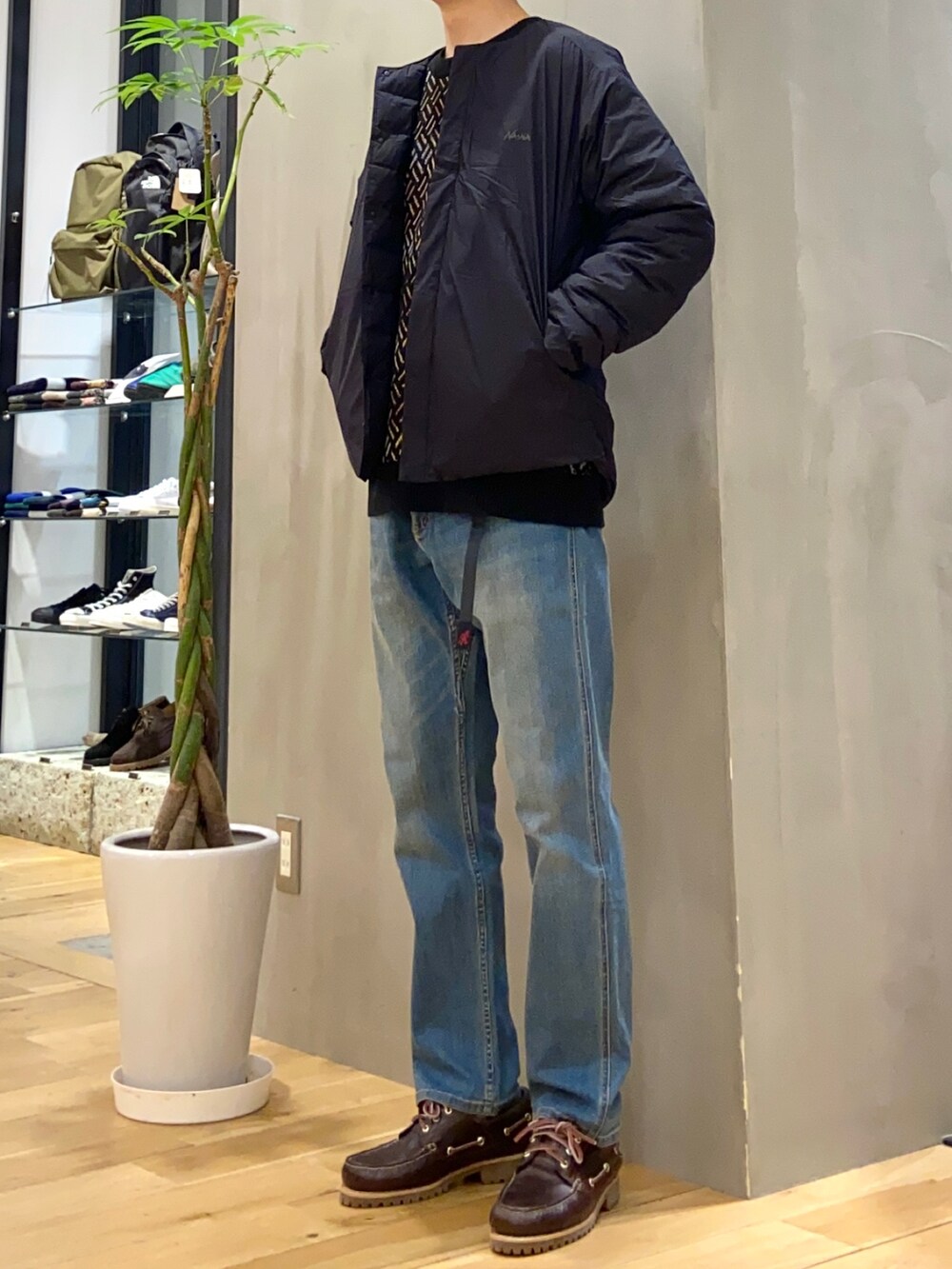 ブラック系のダウンジャケット/コート、ブルー系のその他パンツ、ブラウン系のスニーカーを着用したメンズの冬コーディネートの3枚目の写真