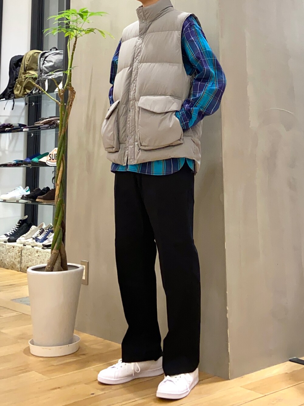 グレー系のダウンベスト、ブラック系のその他パンツ、ブラック系のスニーカーを着用したメンズの秋コーディネートの3枚目の写真