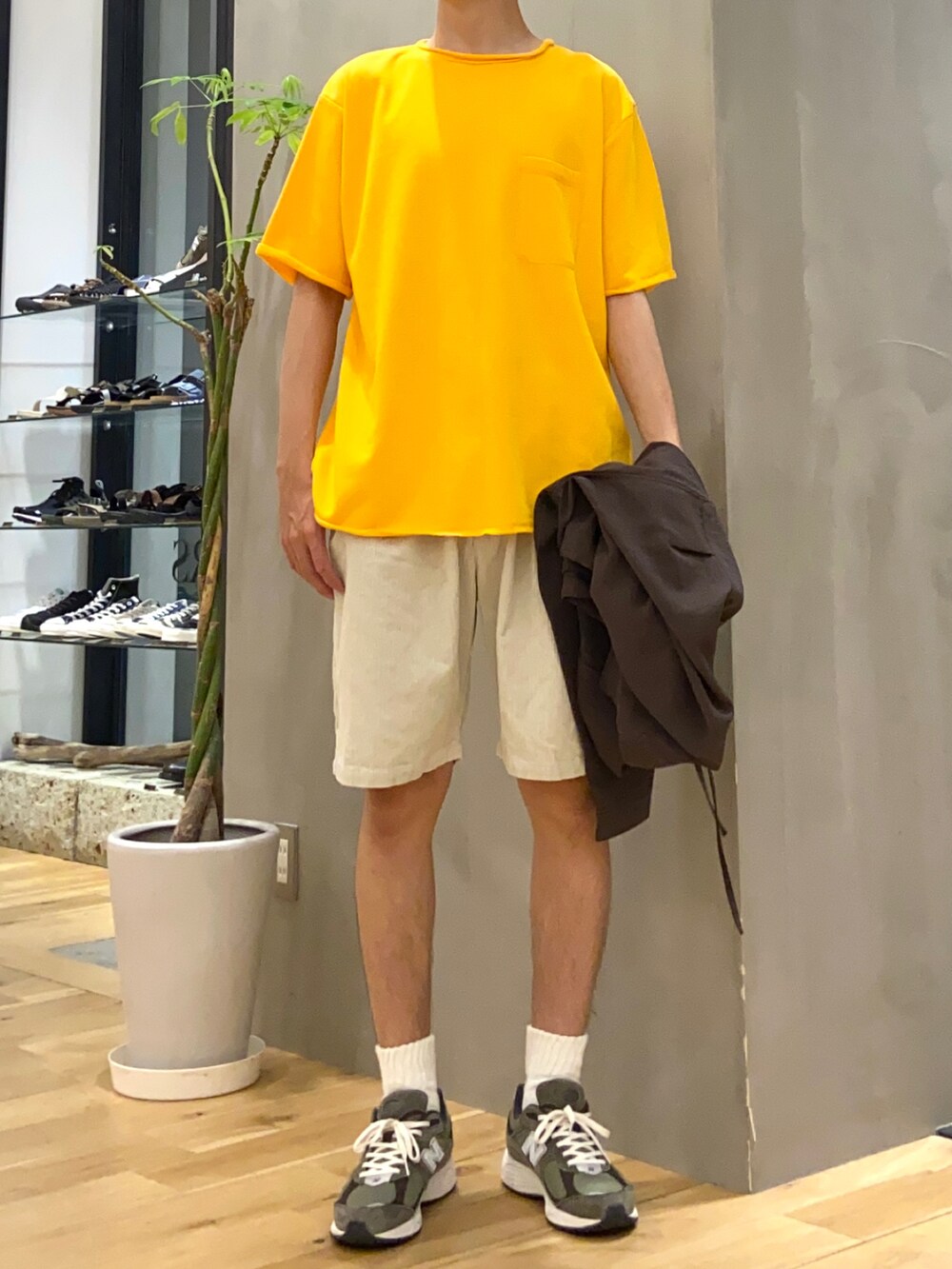 ブラウン系のブルゾン、イエロー系のTシャツ/カットソー、ホワイト系のその他パンツを着用したメンズの夏コーディネートの2枚目の写真