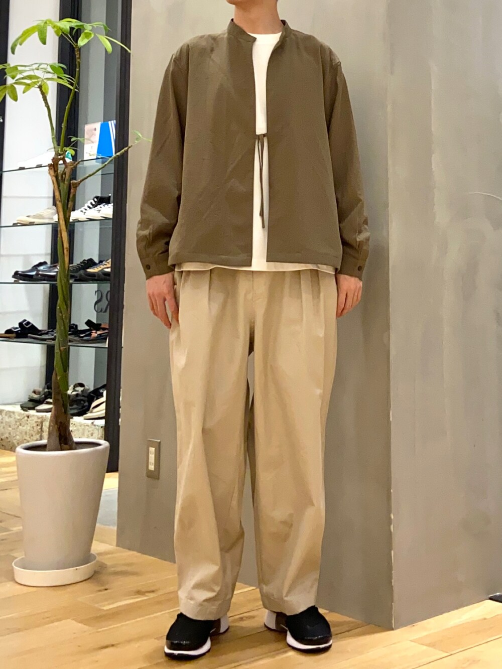 グリーン系のブルゾン、ホワイト系のTシャツ/カットソー、ベージュ系のその他パンツを着用したメンズの春コーディネートの4枚目の写真